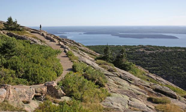 A person enjoying the view from on top of Cadillac Mountain. Located on Mount Desert Island - Acadia National Park, Maine, USA.