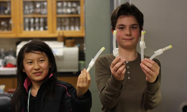 NYC students Lennie Ma and Xander Plossl hold equipment that will be used to conduct an experiment of their design on the International Space Station. school science laboratory