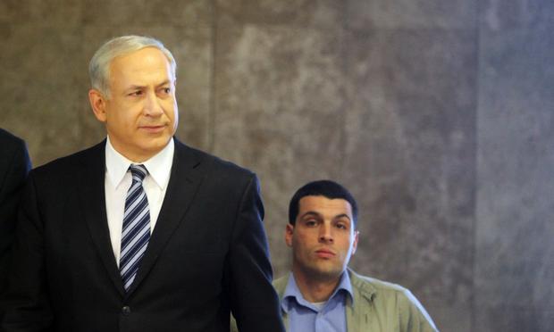 Israeli Prime Minister Benjamin Netanyahu looks to the press and government workers at the top of the stairs as he arrives to his Jerusalem offices to chair the weekly cabinet meeting on March 14.