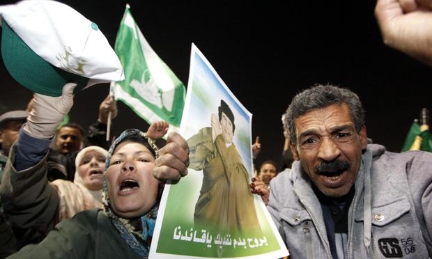 Supporters of Libyan leader Moammar Gadhafi shout slogans while holding his picture during a pro-government rally in Tripoli on February 18, 2011. Supporters of Libyan leader Moammar Gadhafi shout slogans while holding his picture during a pro-government rally in Tripoli on February 18, 2011.