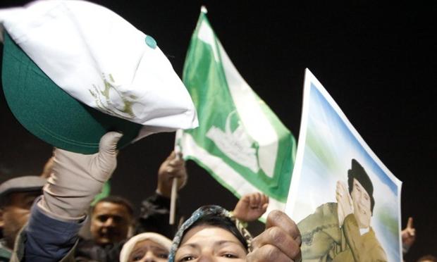 Supporters of Libyan leader Moammar Gadhafi shout slogans while holding his picture during a pro-government rally in Tripoli on February 18, 2011. Supporters of Libyan leader Moammar Gadhafi shout slogans while holding his picture during a pro-government rally in Tripoli on February 18, 2011.