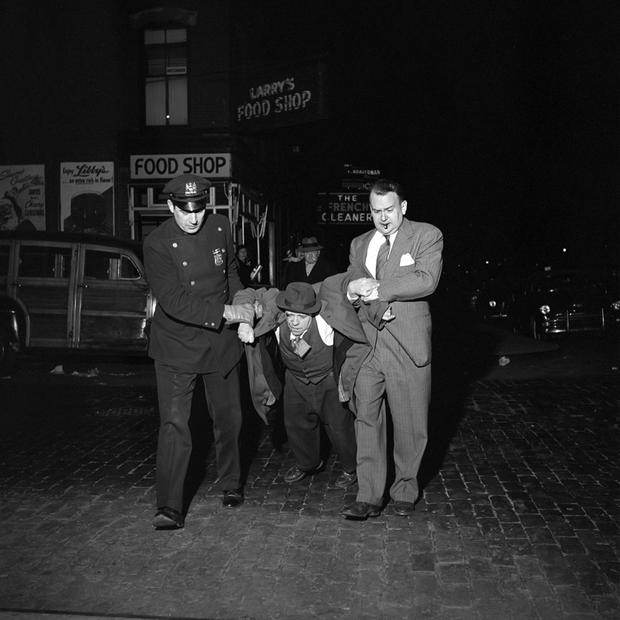 Man being dragged by cops at night still from John Maloof and Charlie Siskel’s FINDING VIVIAN MAIER.