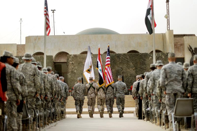U.S. Military personnel holding the US flag, Iraq flag, and the US Forces Iraq colors during a ceremony signifying the departure of U.S. troops from Iraq. December 15, 2011