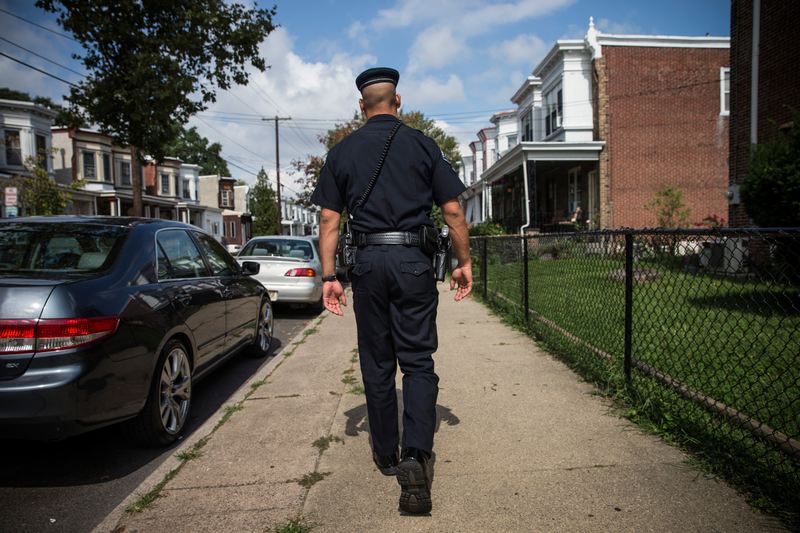 Officer Adam Fulmore, of the Camden County Police Department, goes on a foot patrol on August 22, 2013 in the Parkside neighborhood of Camden, New Jersey.