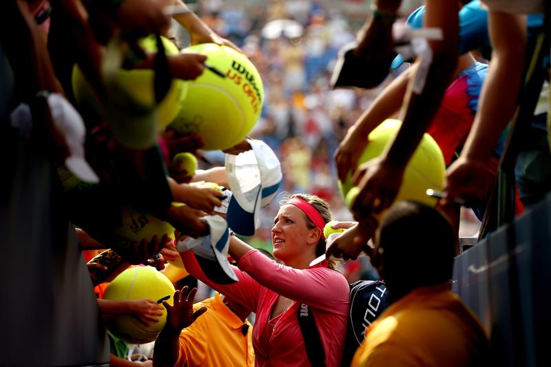 Victoria Azarenka of Belarus signs autographs for fans following her victory in the women's singles third round match against Alize Cornet of France on Day Six of the 2013 US Open.