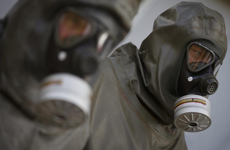 Employees in protective gear are seen during a demonstration in a chemical weapons disposal facility at GEKA.