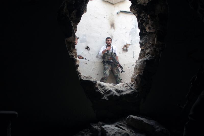 Rebel fighters hold a position in a damaged building during clashes with Syrian government forces in the northeastern city of Deir Ezzor, on November 11, 2013.