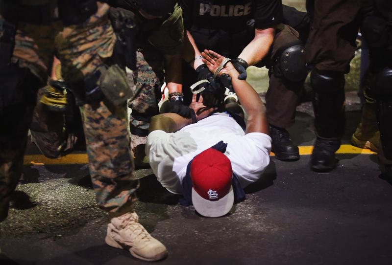 Police arrest a demonstrator protesting the killing of teenager Michael Brown on August 19, 2014 in Ferguson, Missouri.