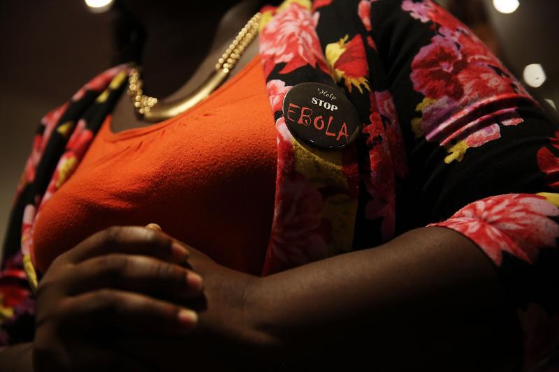 A woman wears a 'Stop Ebola' pin as she joins other members of the Staten Island Liberian community at a 'War Against Ebola' fundraiser on October 5, 2014 in New York City.