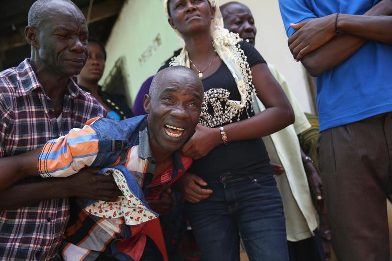 Varney Jonson, 46, grieves as an Ebola burial team takes away the body of his wife Nama Fambule for cremation on October 10, 2014 in Monrovia, Liberia.