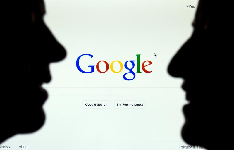 A picture taken on October 17, 2014 in Lille, France shows two figures in front of the Google internet homepage.