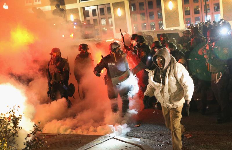 Police guard the Ferguson police department as rioting erupts following the grand jury announcement in the Michael Brown case on November 24, 2014 in Ferguson, Missouri.