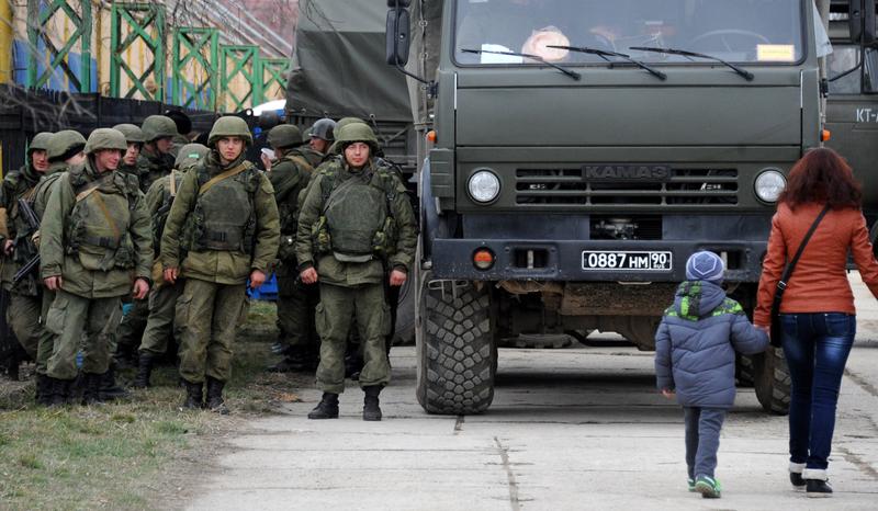 Military personnel stand near a Russian-made Kamaz truck in the eastern Crimea'a port city of Feodosiya on March 2, 2014.
