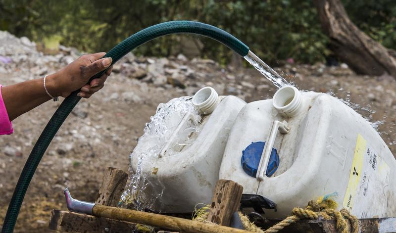 A resident of Mexico City fills containers with water from a public water pump in Mexico City.