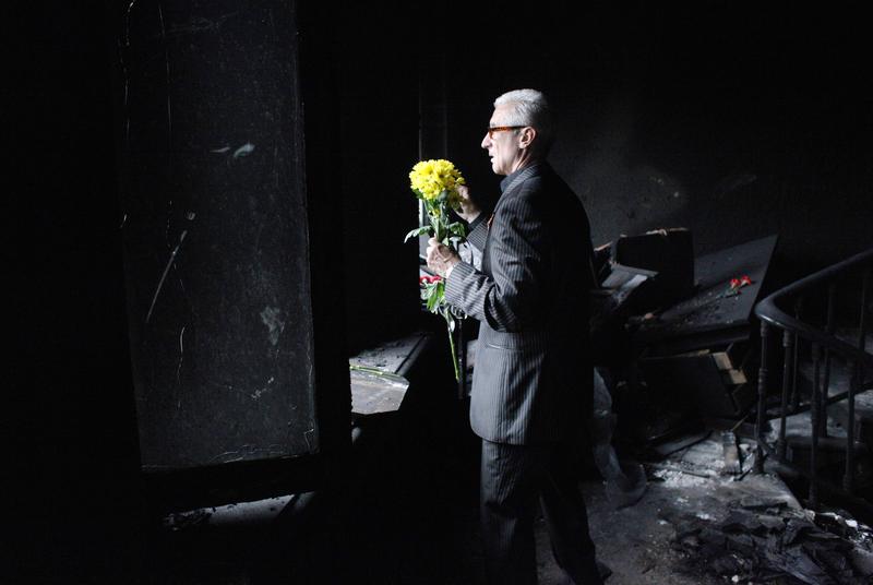 A man holds flowers he brough in homage of the victims as he stands inside the burned trade union building in the southern Ukranian city of Odessa on May 4, 2014.