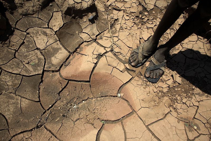 A young boy from the remote Turkana tribe in Northern Kenya stands on a dried up river bed on November 9, 2009. Their way of life is threatened by climate change.