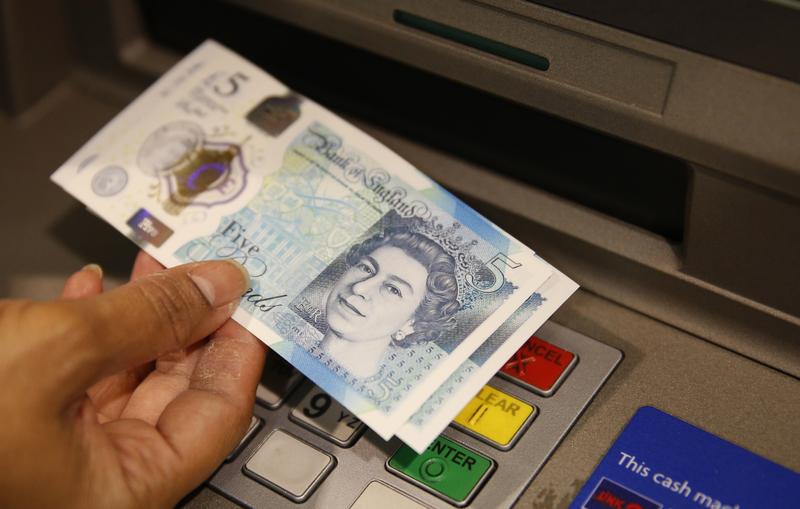 Sept. 13, 2016: A member of staff at a branch of Halifax bank, in London, displays a new British 5 pound sterling note, made from polymer, which is being launched Tuesday.