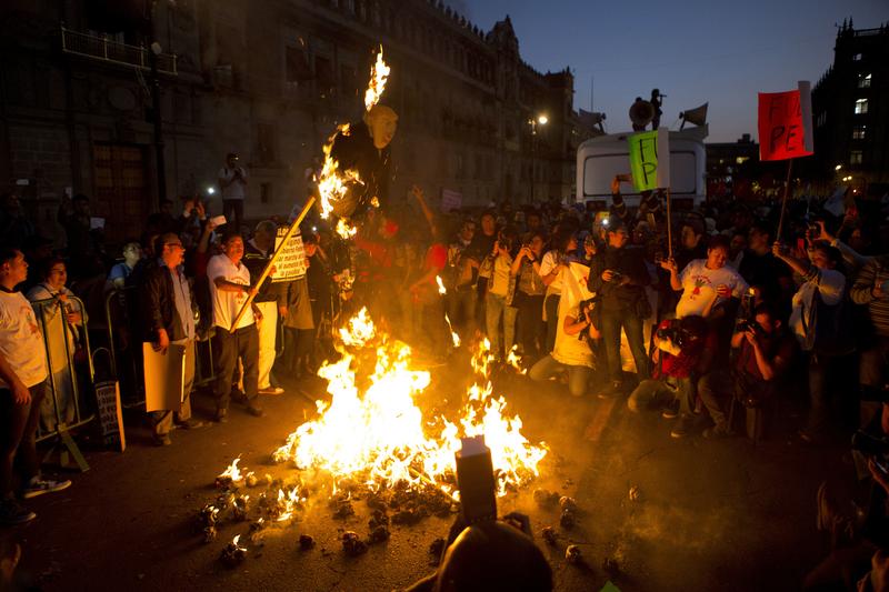 Protestors burned representations of Donald Trump and Enrique Pena Nieto during a march by thousands angry at the government following a 20 percent rise in gas prices. Jan. 9, 2017
