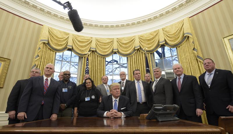 President Donald Trump poses with union leaders in the Oval Office at the White House in Washington, Monday, Jan. 23, 2017.