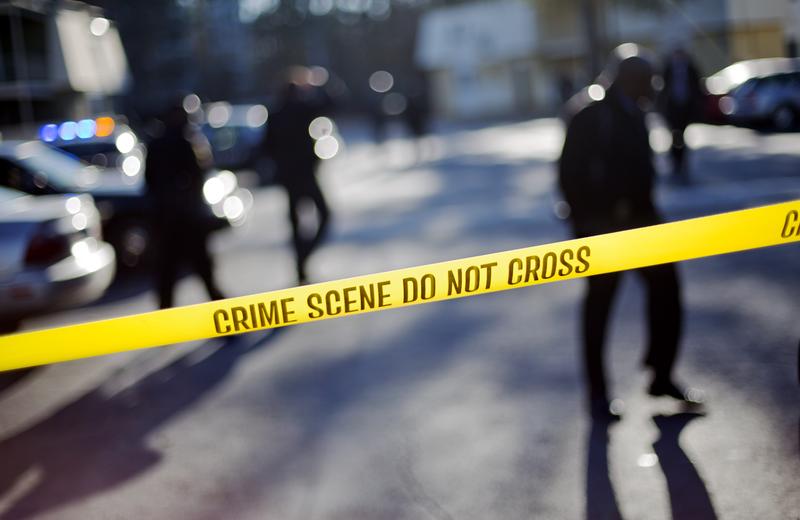 Crime scene tape blocks of the area of an apartment complex where authorities say two police officers were shot, leading to a neighborhood search for the suspected gunman, Friday, Dec. 12, 2014, in GA