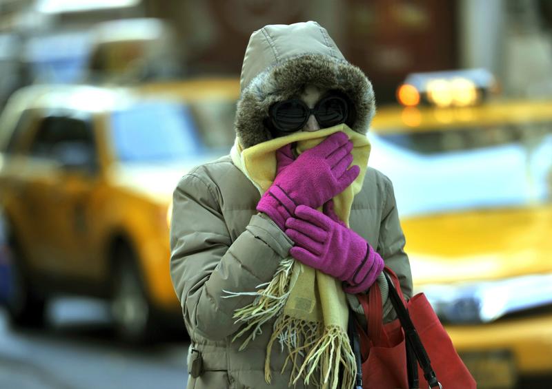 A woman braces from the cold during the morning commute in New York City as temperatures dropped into the lower 30s. November 2013