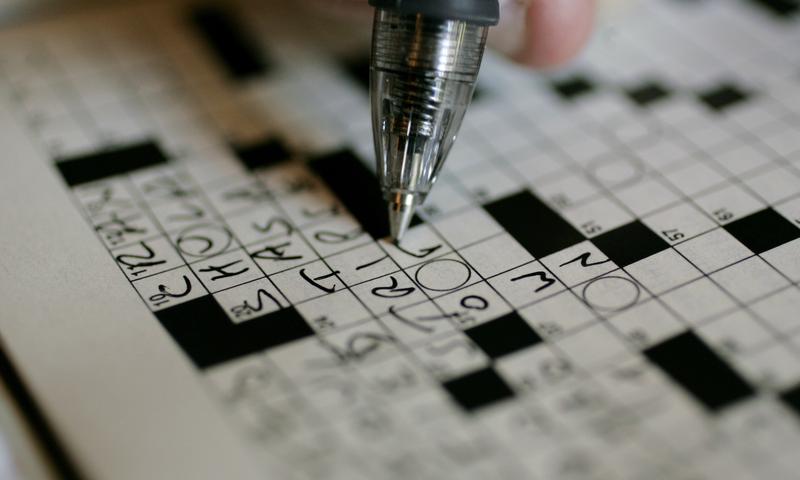 A puzzle fan works on a New York Times crossword puzzle