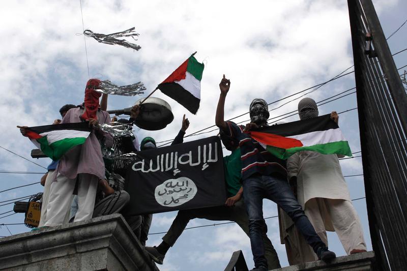 Kashmiri protesters hold up a flag of the Islamic State of Iraq and the Levant (ISIL), during a protest against Israeli military operations in Gaza, on July 18, 2014 in Srinagar, India.