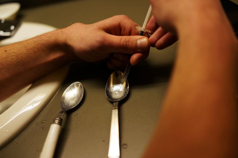 Drugs are prepared to shoot intravenously by a user addicted to heroin.