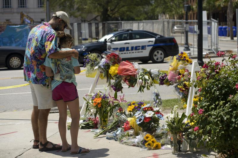 People visit a makeshift memorial near the Emanuel AME Church June 18, 2015 in Charleston, South Carolina, after a mass shooting at the Church on the evening of June 17, 2015.