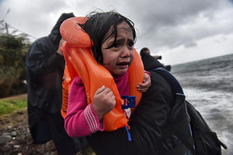 Refugees and migrants arrive at Lesbos island after crossing the Aegean sea from Turkey on October 23, 2015.