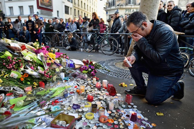 Members of the public gather to lay flowers and light candles at La Belle Equipe restaraunt on Rue de Charonne following Fridays terrorist attack on November 15, 2015 in Paris, France.