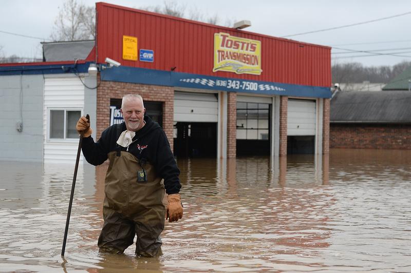 A man in Fenton, Missouri, wades through the flooding to inspect his business.
