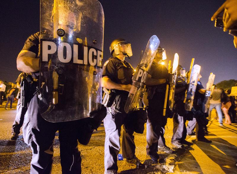 Protesters face off with Baton Rouge police in riot gear across the street from the police department on July 8, 2016 in Baton Rouge, Louisiana.