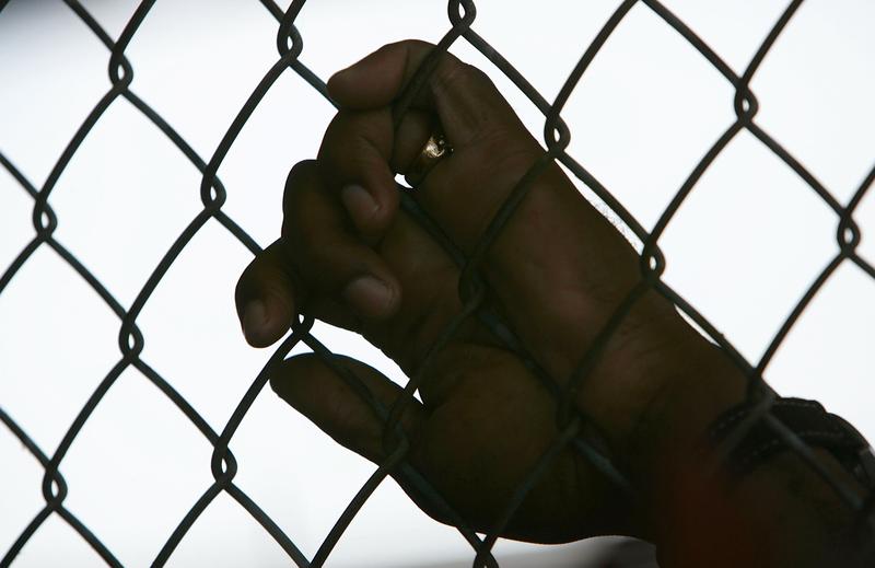 An inmate holds onto a fence at the Louisiana State Penitentiary April 23, 2006 in Angola, Louisiana.