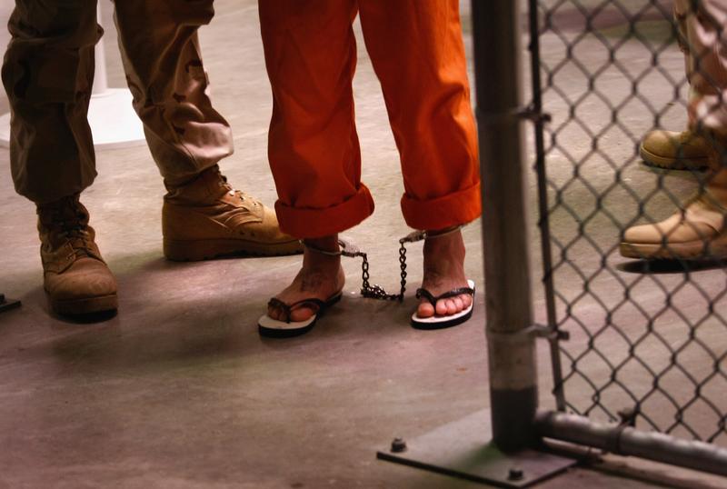 A 'non-compliant' detainee is escorted by guards after showering inside the U.S. military prison for 'enemy combatants' on October 27, 2009 in Guantanamo Bay, Cuba.