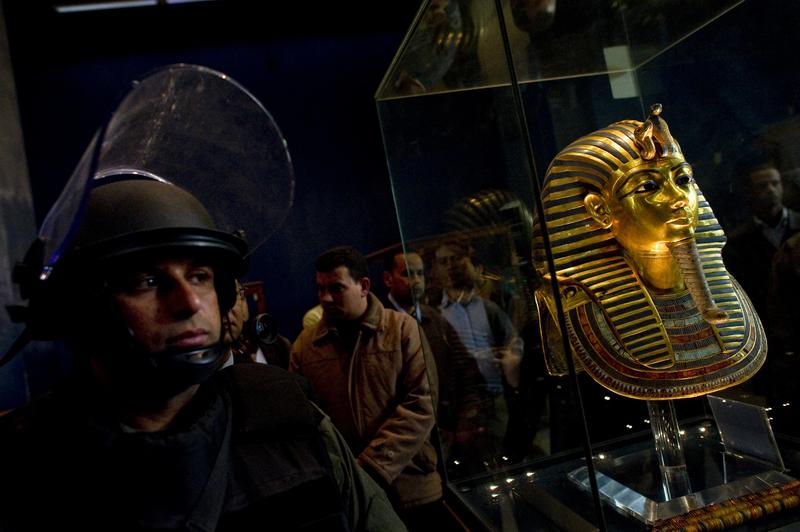 A soldier stands guard next to Tutankhamun's gold funerary mask inside the Egyptian Museum as Egyptian state minister of antiquities Zahi Hawass talks to reporters on February 16, 2011