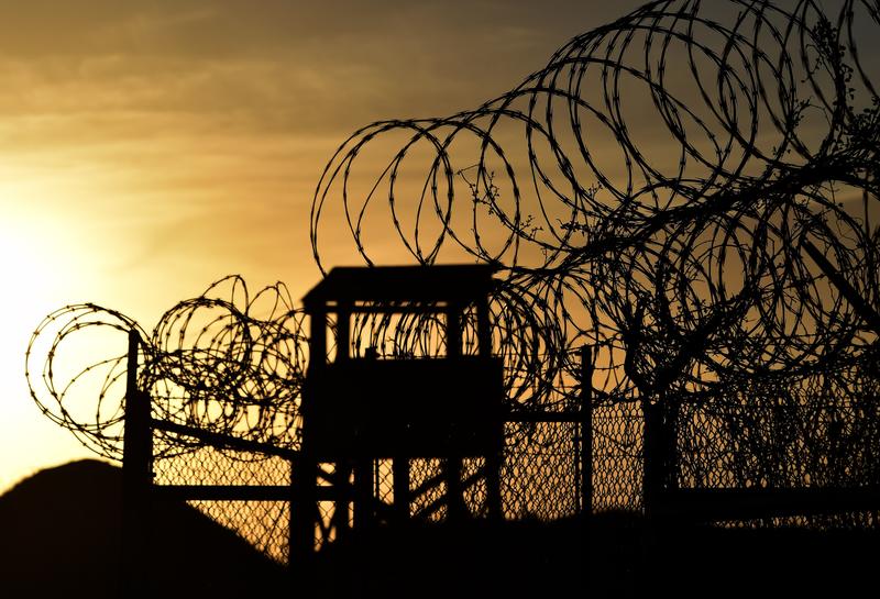 Razor wire-topped fence and a watch tower at the abandoned 'Camp X-Ray' detention facility at the US Naval Station in Guantanamo Bay, Cuba, April 9, 2014.