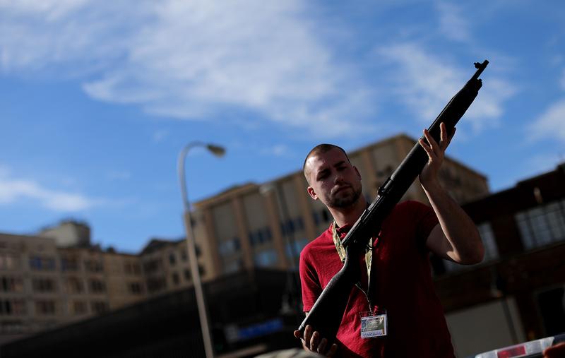 Second Amendment supporter and gun enthusiast Shade Haddox displays an unloaded rifle being sold in an impromptu auction across the street from a gun buy back program in Dallas, TX, Jan 19, 2013