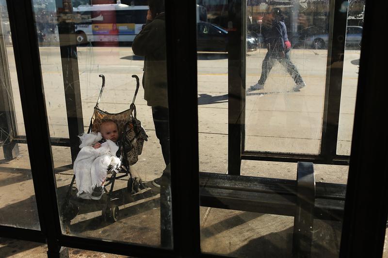 A child and mother wait for a bus on October 11, 2012 in Camden, NJ. According to the U.S. Census Bureau, Camden is the most impoverished city in the United States.