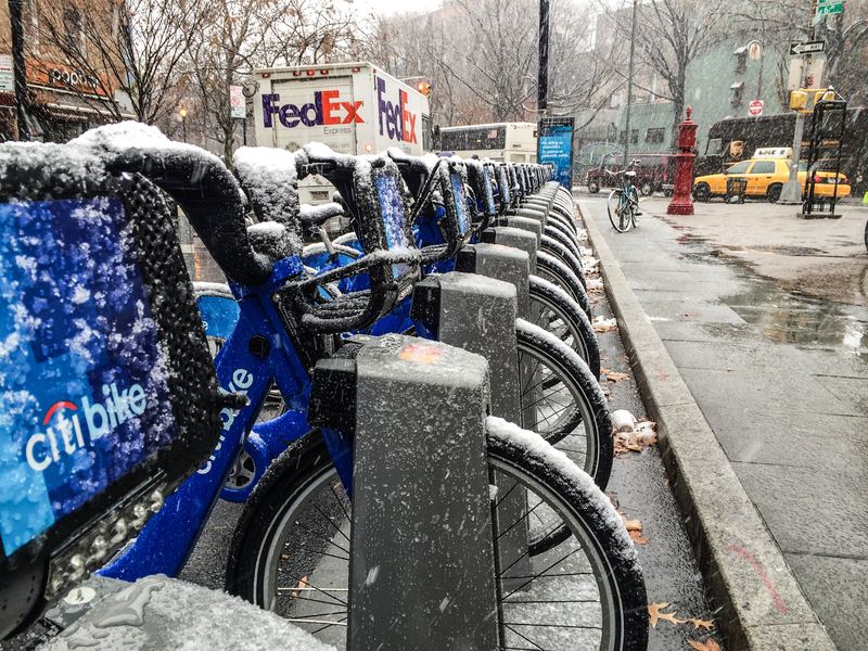 A Citi Bike docking station covered in wet snow.
