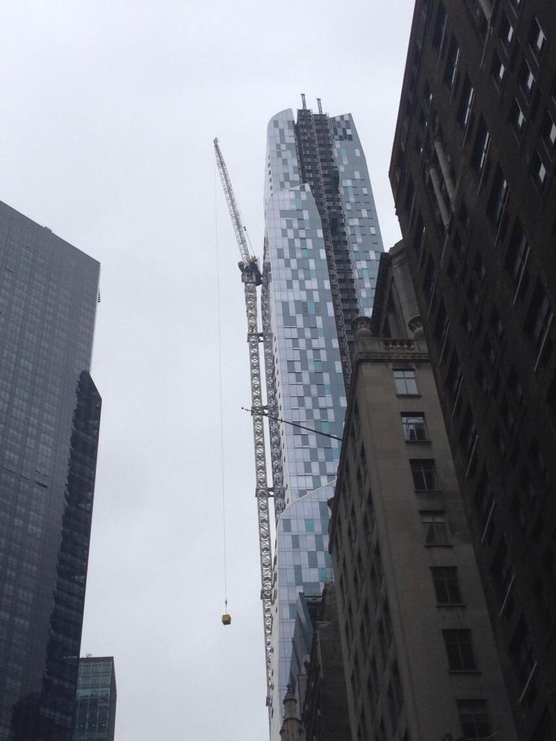 A stuck crane dangles over W. 57th Street near Carnegie Hall