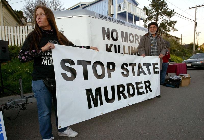 Melanie Bostic (L) of Lancaster, California and Michael Wharton of San Leandro, California hold a sign outside of the California State Prison at San Quentin February 9, 2004 in San Quentin, California