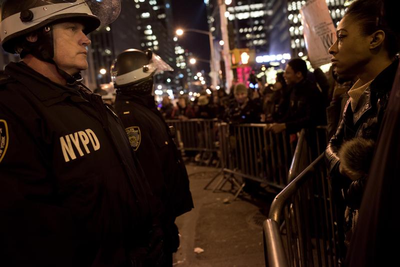 A police officer and a protester face off across the barricades near Rockefeller Center