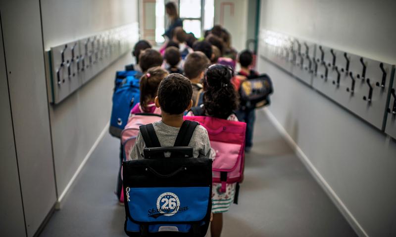 Children wait in line to go to class on the first day of school
