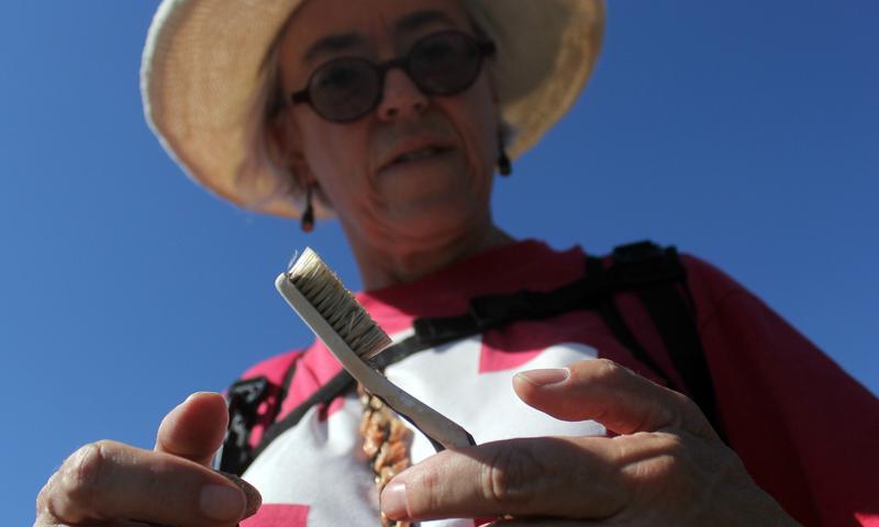 Artist Deborah McCullough holds a toothbrush found along the US-Mexico border. Discarded toothbrushes are a common in the desert; McCullough uses them as material in her art installations.