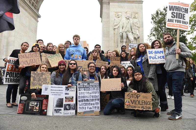 College students pose with signs in front of Washington Square arch prior to marching on October 24th, 2015.
