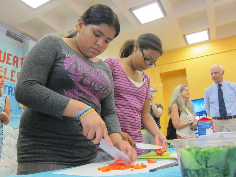 Two students chop vegetables to be used in omelets in a cooking class meant to teach students math and nutrition.