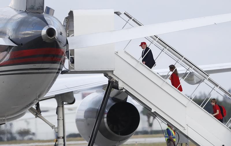 President-elect Donald Trump, followed by his wife Melania Trump and son Barron Trump, boards his plane at Palm Beach International Airport, Sunday, Nov. 27, 2016.