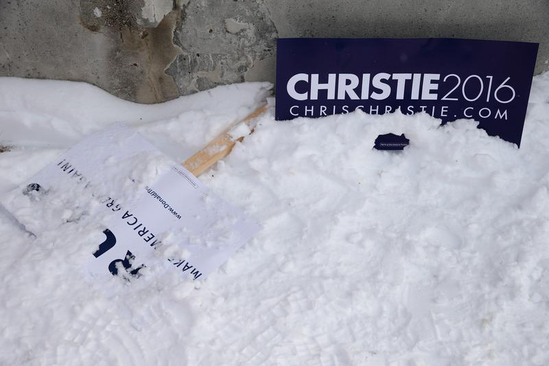 Campaign sings for Republican presidential candidates Donald Trump and New Jersey Governor Chris Christie lie on the ground outside the polling place at Webster School on primary day February 9, 2016.