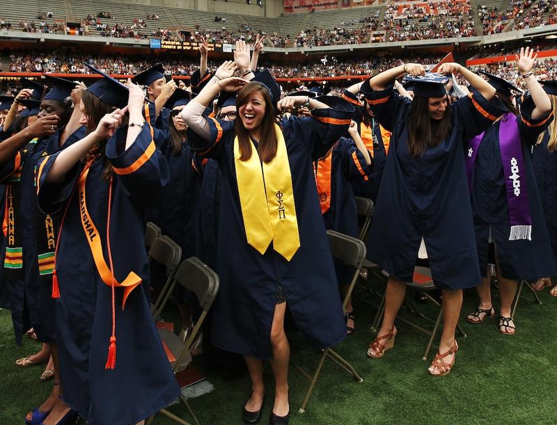 Graduates high-five at the 2012 Syracuse University commencement. Economists tell us that degrees lead to higher pay and a happier life, but how does college actually produce those gains?